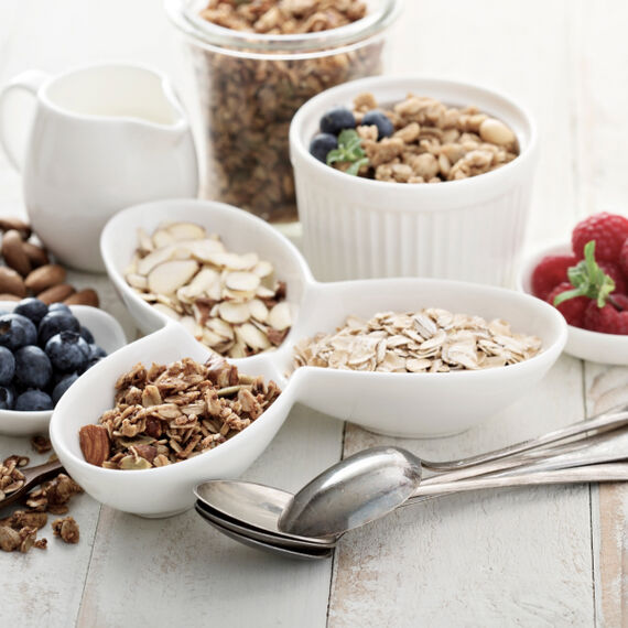 Körner, Haferflocken und Früchte in kleinen Schalen für Müsli