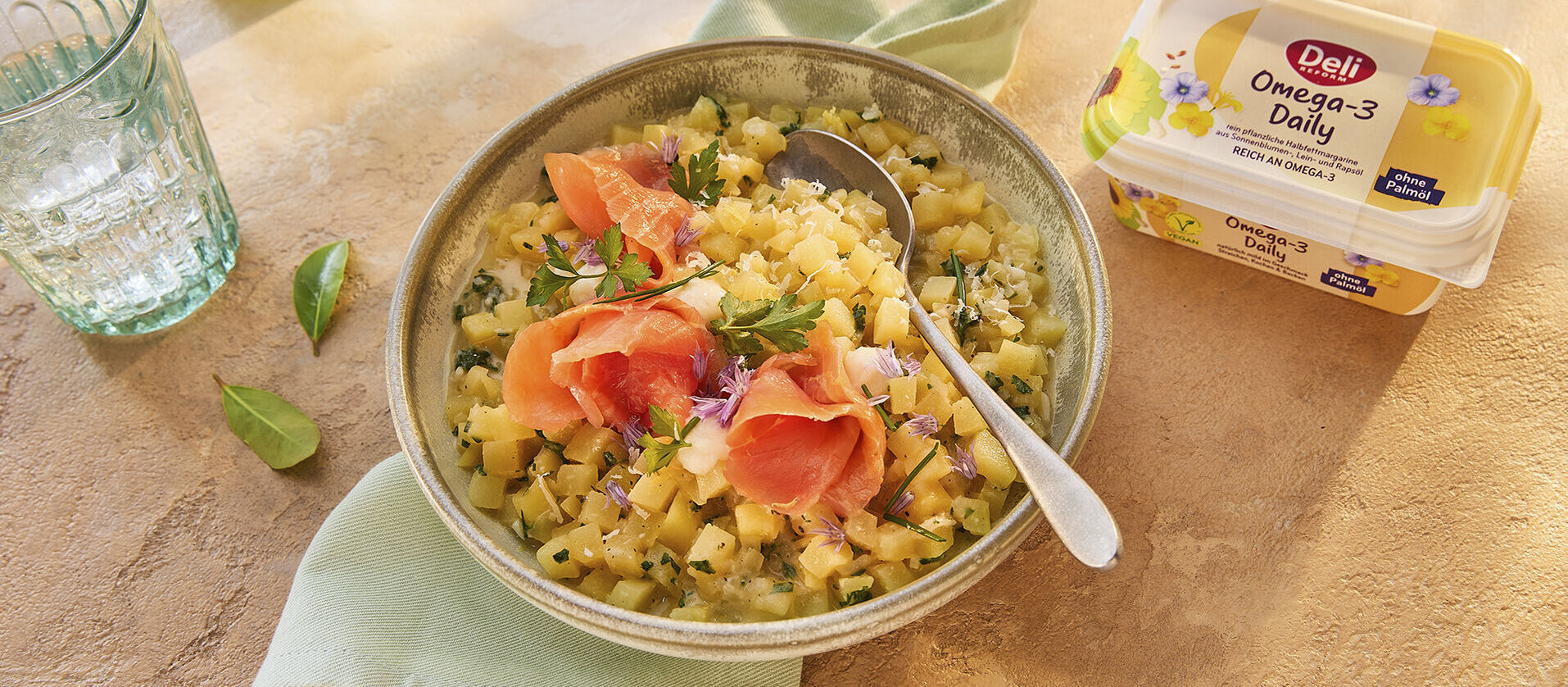 Schüssel mit Kartoffelrisotto und Räucherlachs, daneben eine Packung Deli Omega-3 Daily.
