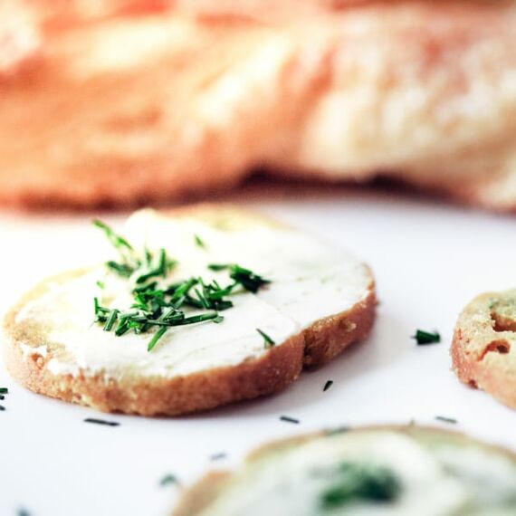 Zwei Baguettescheiben mit Margarine und Schnittlauch belegt