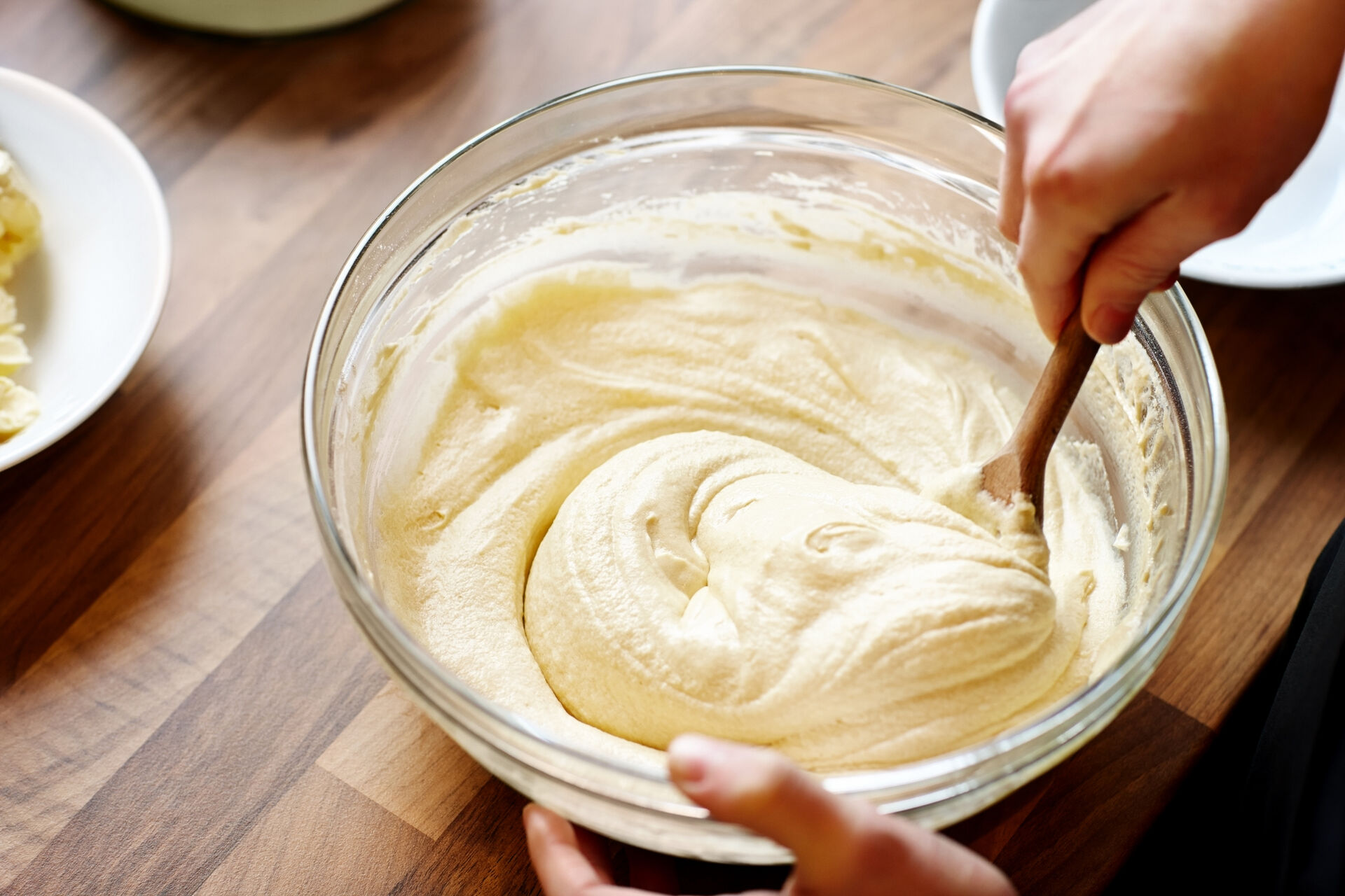 Eine Person rührt Kuchenteig in einer großen Schüssel.