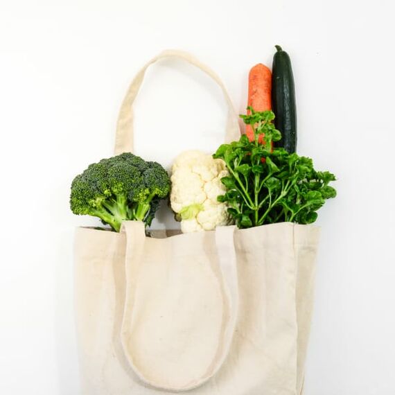  Ein Einkaufsbeutel mit Brokkoli, Blumenkohl, Karotte, Gurke und Petersilie.