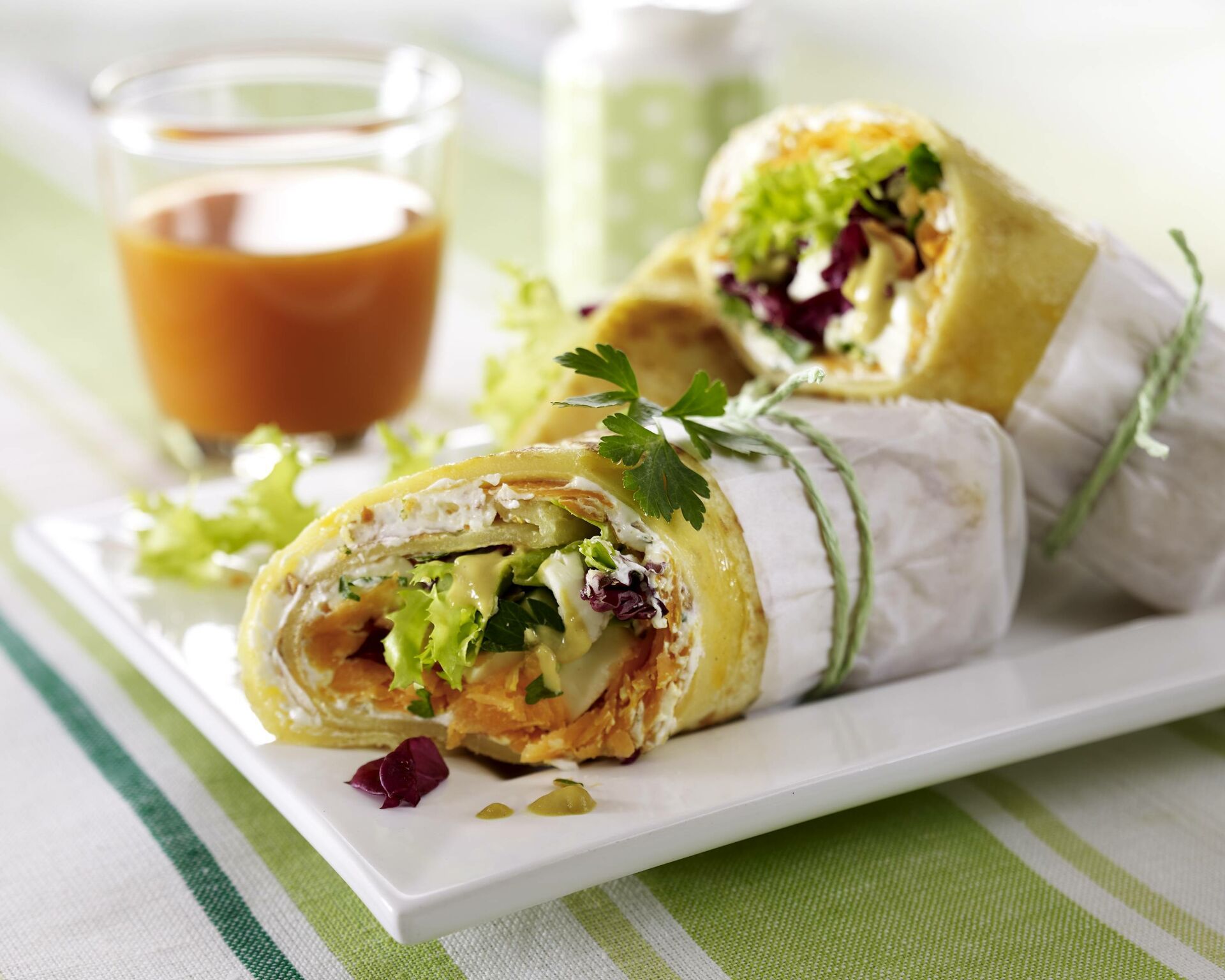 Nahaufnahme von vegetarischen Wraps mit Möhren und Mozzarella, eingewickelt in Butterbrotpapier