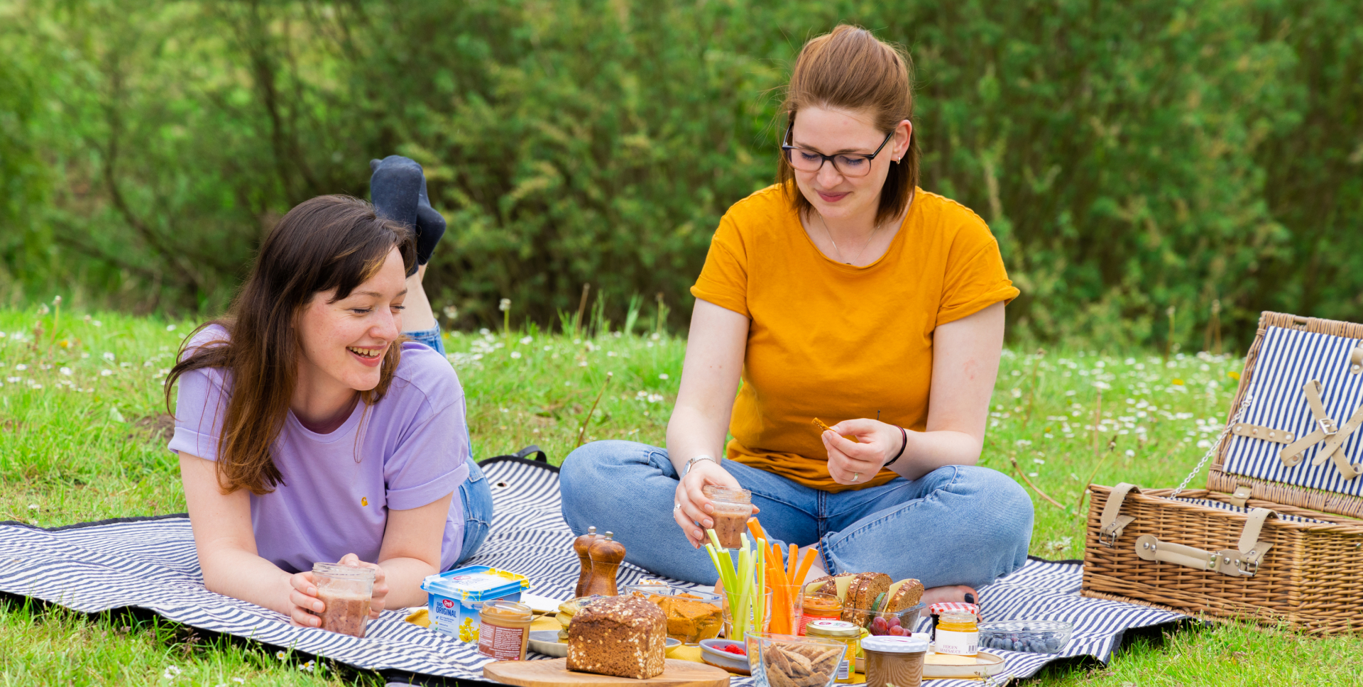 Zwei Frauen sitzen auf einer Picknickdecke